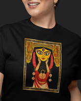 Person wearing a black t-shirt with a colorful graphic design on a dark background
